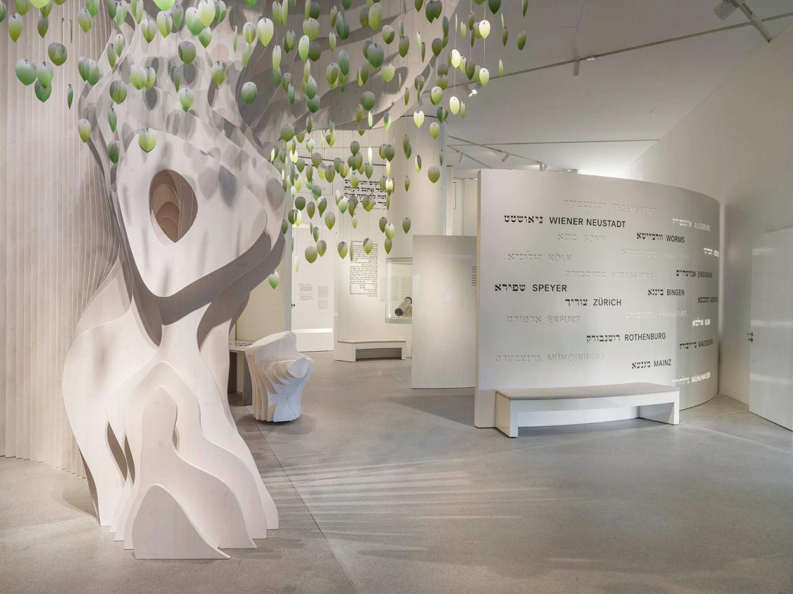 Eingangsbereich Dauerausstellung mit stilisiertem Baum, an dem grüne Blätter hängen