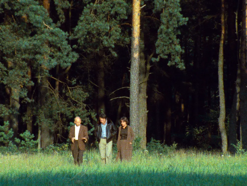 Claude Lanzmann (mitte) und Barbara Janicka (rechts) gehen mit Jan Piwonski (links) &uuml;ber das Gel&auml;nde des Vernichtungslagers Sobibor