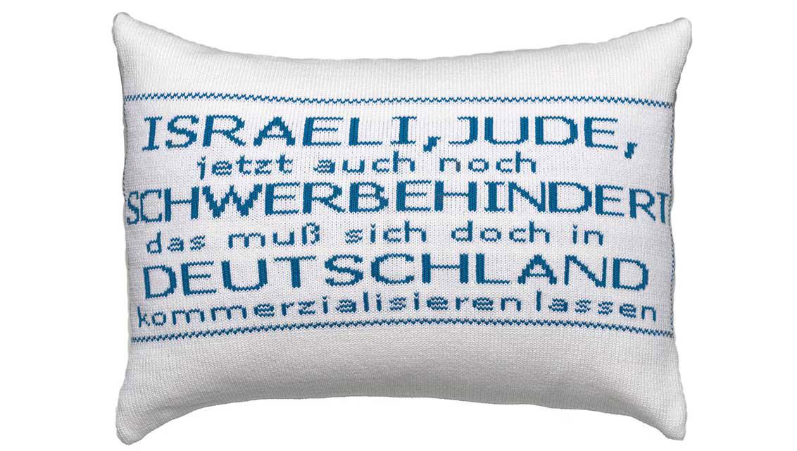White decorated cushion with blue writing