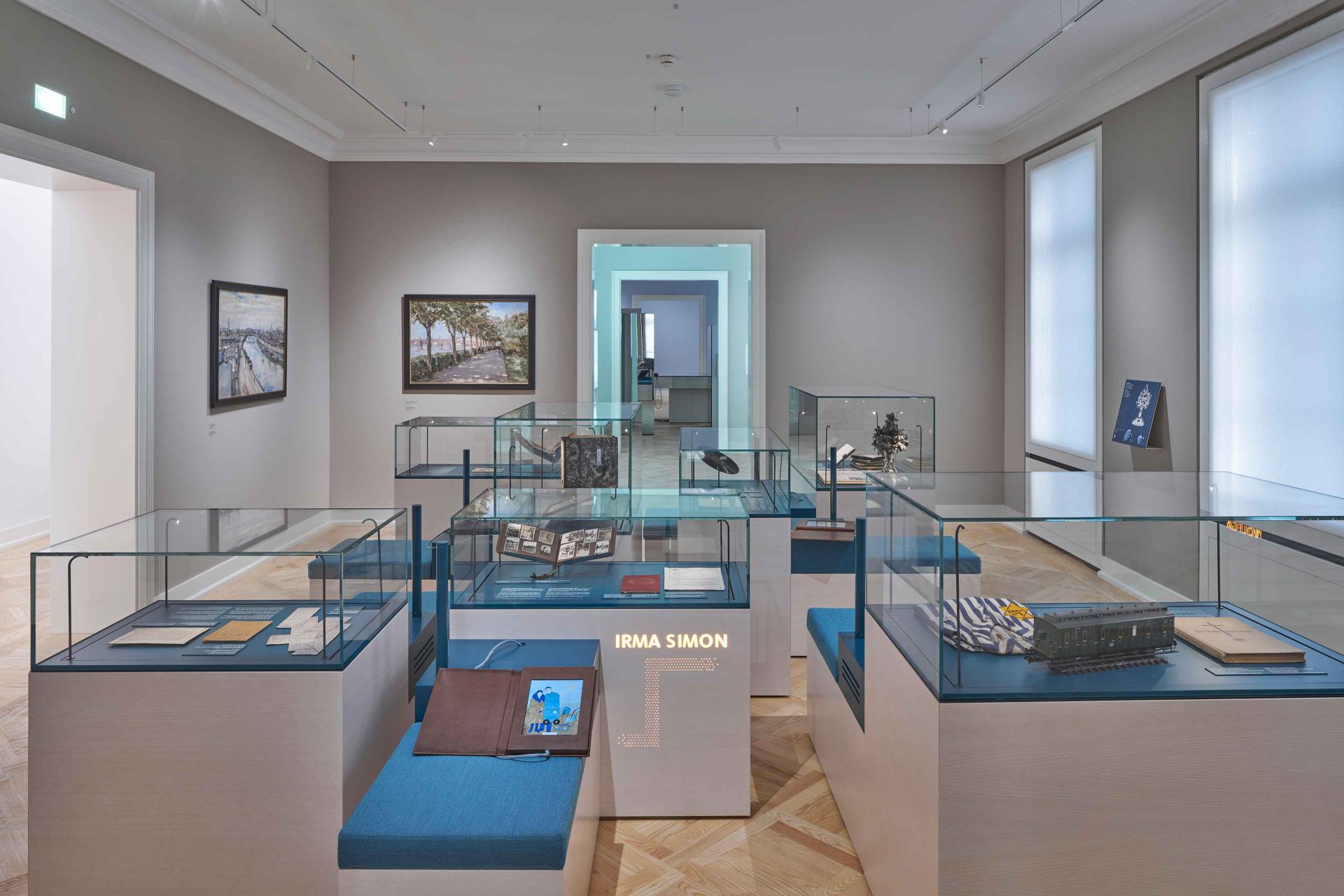 Exhibition space with showcases containing objects on a blue background.