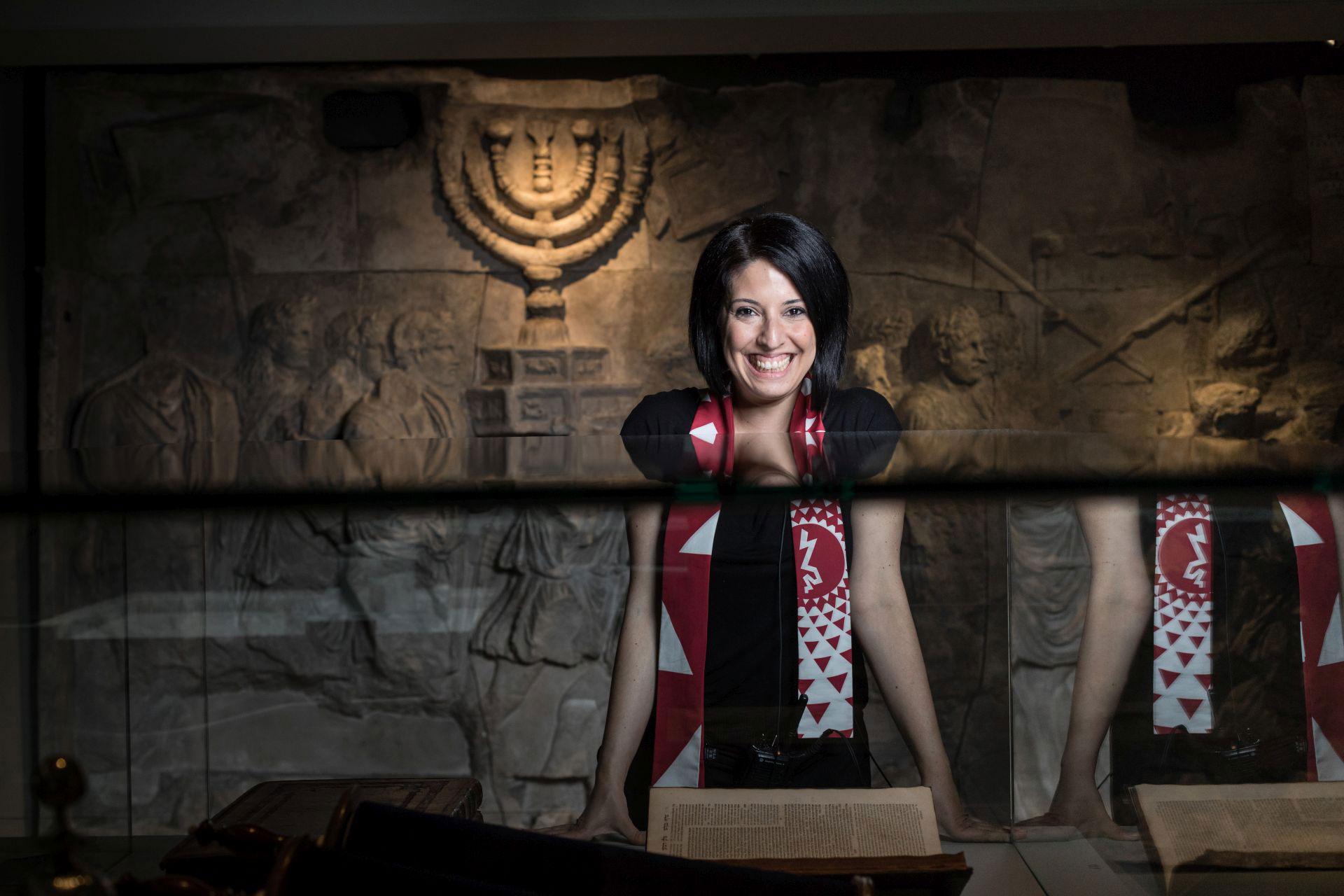 Eine lachende Frau steht in einem Raum der Ausstellung „Welcome to Jerusalem“.