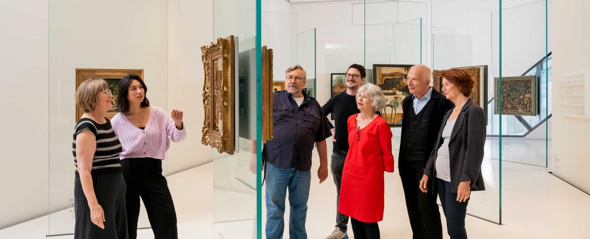 Visitors orient themselves in the first room of the Jewish Museum's permanent exhibition, read or look at an overview map.