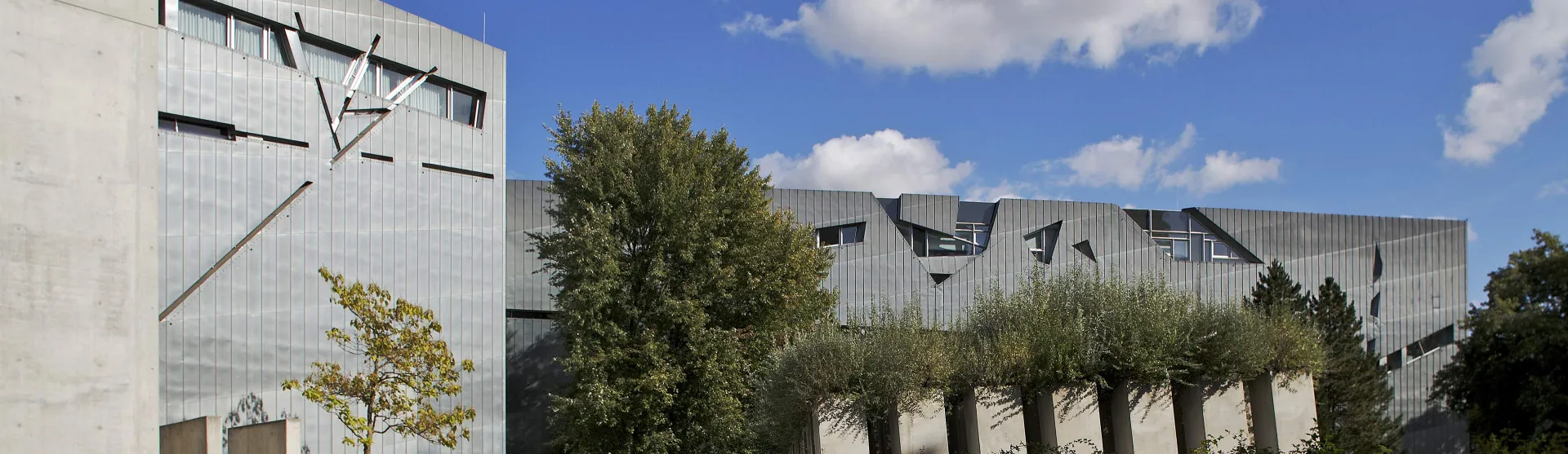 Blick auf den Libeskindbau, im Vordergrund die Stelen des Garten des Exil