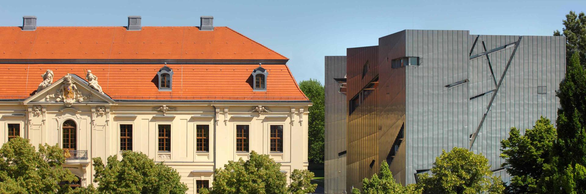 Blick von der Straße auf das Jüdische Museum Berlin: die Fassade des barocken Altbaus und daneben der Libeskind-Bau aus Titanzink