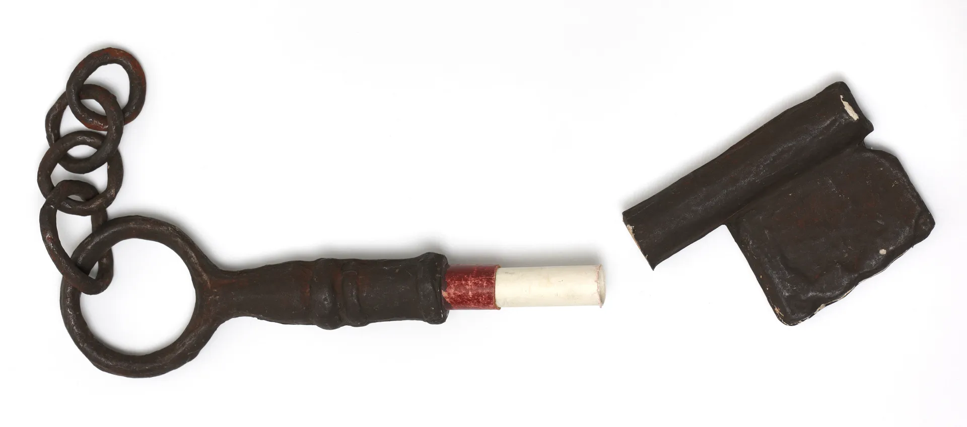 Dark brown cardboard key with a rolled up note inside
