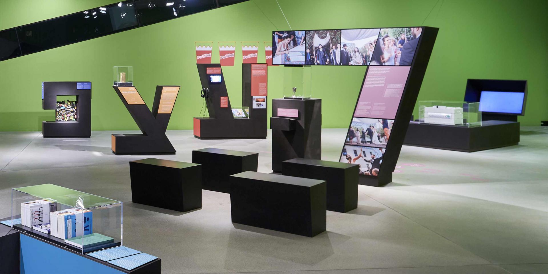 View of an exhibition hall with vitrines in form of huge Hebrew letters