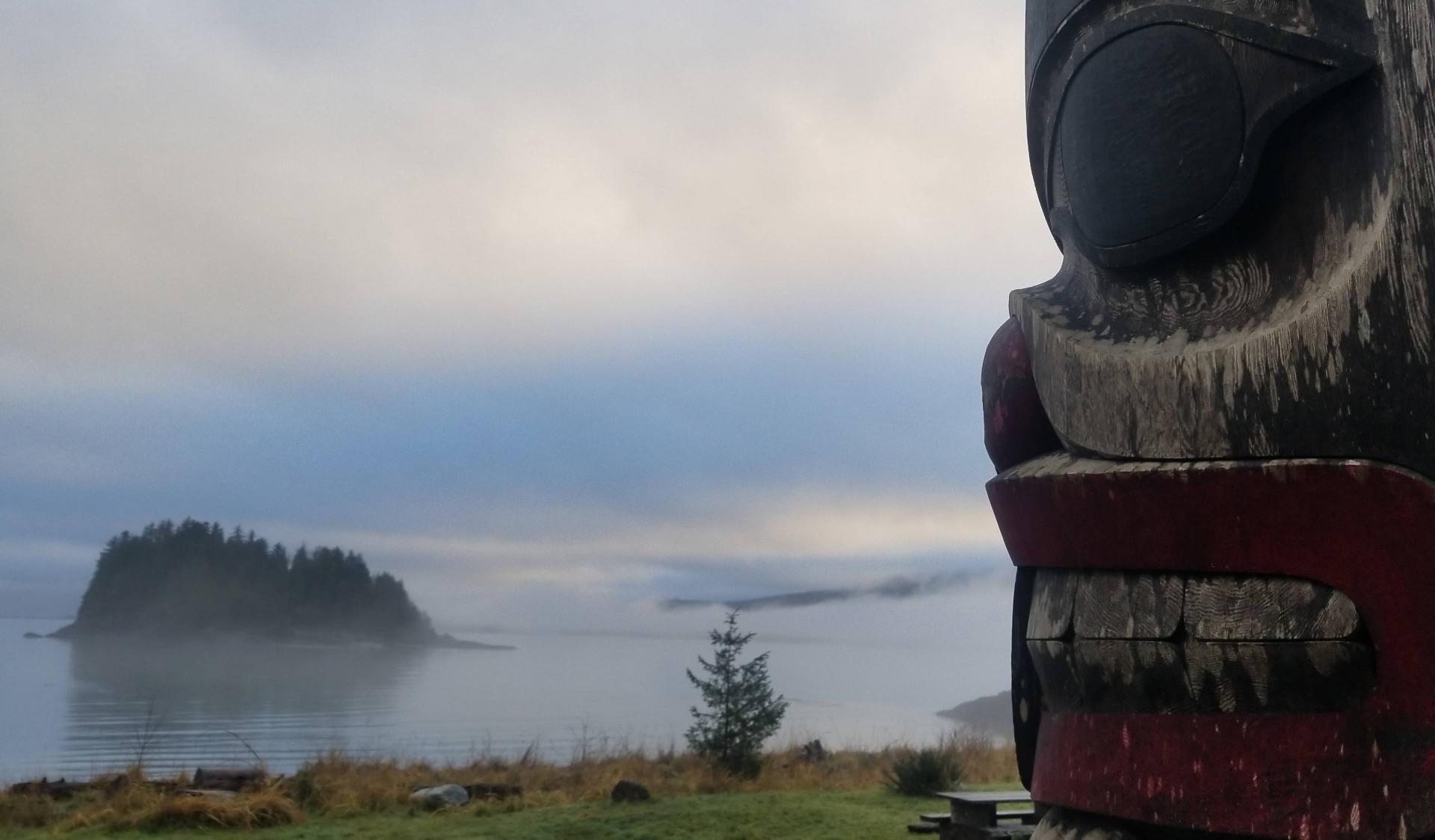Photography of a totem pole in a foggy landscape with lake