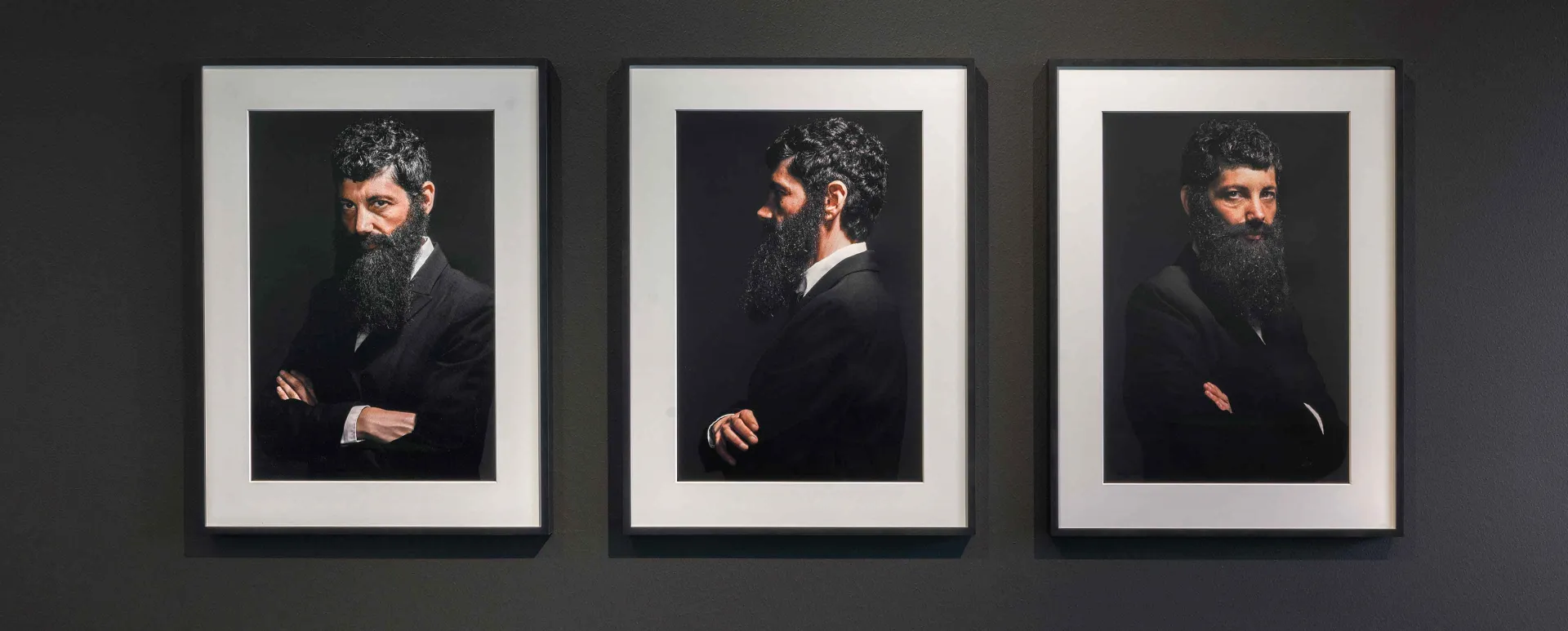Three self portraits of a person with thick hair and long beard in a suit.