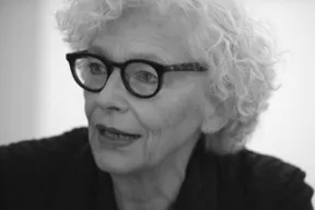 Schwarz-Wei&szlig; Foto. Portrait von einer Frau mit einer schwarzen Brille, die zur linken Seite schaut. 