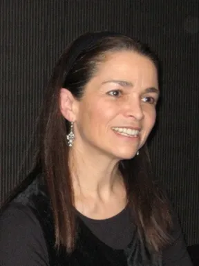 A woman looks to the side and smiles.