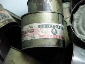 Eine Dose mit der Aufschrift &raquo;Giftgas Zyklon&laquo; und einem Totenkopf auf einem Haufen weiterer solcher Dosen.