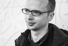 Black and white portrait of a young man with glasses in half profile