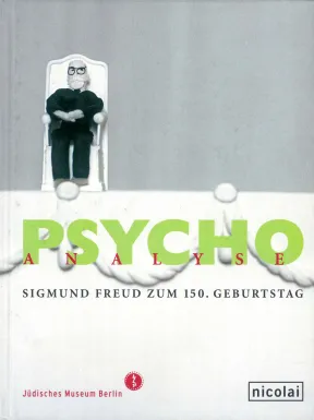 Catalogue cover for the exhibition &ldquo;PSYCHOanalyse&ldquo;: a small cloth figurine of a sitting man with a white beard and glasses.