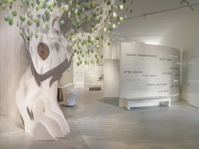 Ein Baum aus Holz, an dem gr&uuml;ne Papierbl&auml;tter h&auml;ngen