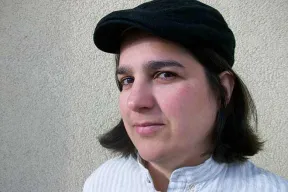 Portr&auml;t einer Frau, die eine Schieberm&uuml;tze tr&auml;gt und direkt in die Kamera schaut 