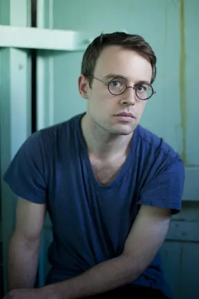Portr&auml;tfoto eines jungen Mannes mit Brille