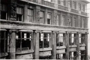 Das Foto zeigt ein Geb&auml;ude mit zerst&ouml;rten Fensterscheiben und die Verw&uuml;stung im Inneren der ersten beiden Stockwerke des Kaufhauses. Das Foto ist auf H&ouml;he des 2. Stockwerks, vermutlich vom gegen&uuml;berliegenden Geb&auml;ude aus, aufgenommen worden.