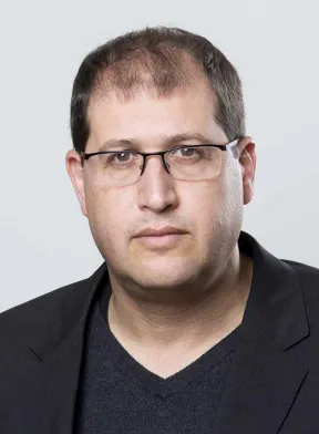 Portr&auml;t eines Mannes, in schwarzem Anzug mit Brille.