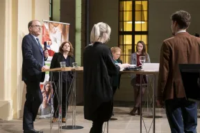 Markus Walz spricht. In seiner Hand ein Mikrophon. Hinter ihm steht L&eacute;ontine Meijer-van Mensch.