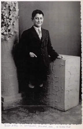 Portr&auml;t von Rudolf Appel stehend in einem Fotostudio. Er tr&auml;gt eine dunklen Anzug, kurze Hosen mit Kniestr&uuml;mpfen.