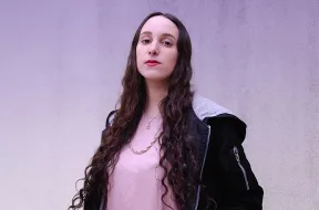 Portrait of Sharon with Star of David necklace, looking challengingly at camera