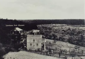 Schwarz-wei&szlig; Fotografie von zwei Landh&auml;usern in einer h&uuml;geligen Landschaft. 