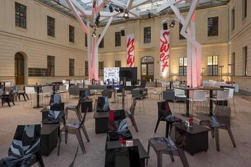 Stühle und kleine Tische im Glashof des Jüdischen Museums Berlin