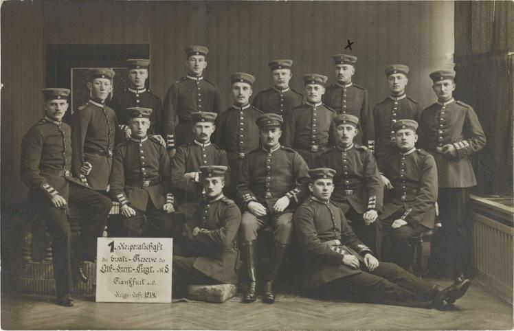 Schwarz-weiß-Foto: 17 uniformierte Soldaten, stehend oder sitzend, Atelieraufnahme