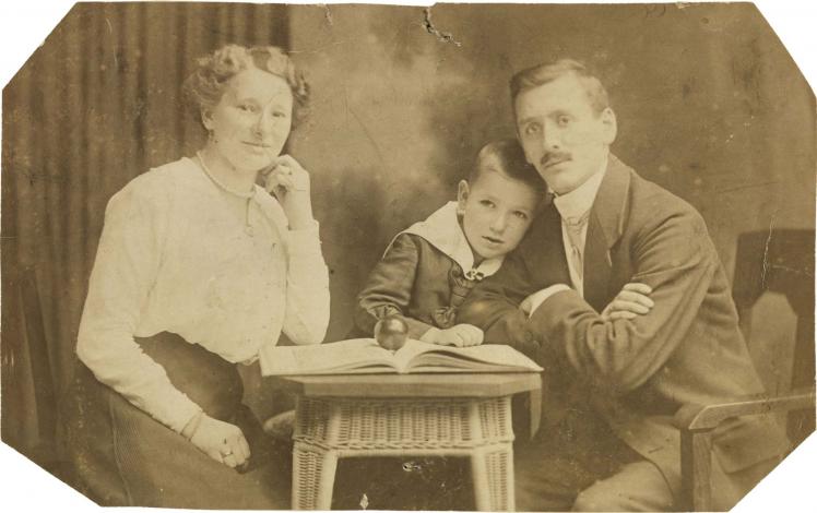 Black-and-white photograph: couple with son in the middle, studio photograph