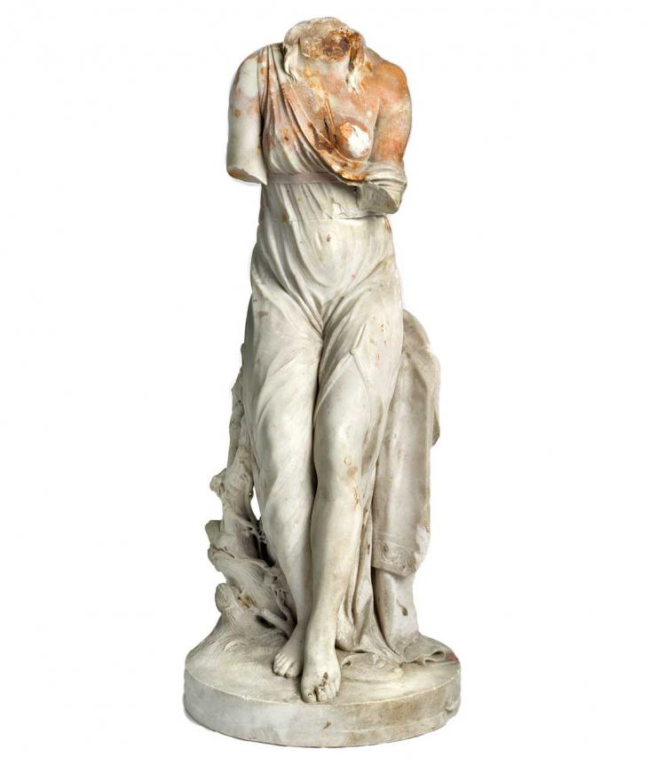 Weibliche Statue mit Rostspuren, der der Kopf fehlt