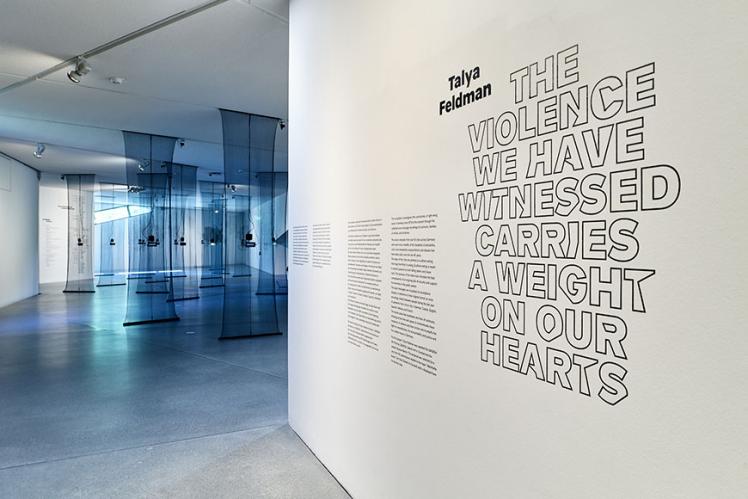 Raumansicht der Ausstellung, im Vordergrund eine Wand mit Text
