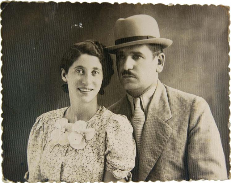  Double black-and-white photographic portrait showing Sally Katz smiling on the left in a floral-patterned dress and Heinrich Katz on the right in a suit and hat.