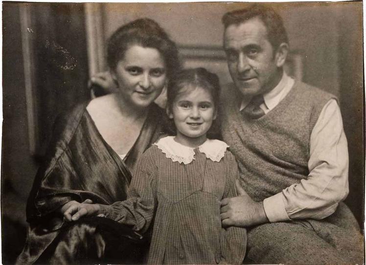 Black-and-white family photograph. Minni and Jakob Steinhardt are seated with Josefa standing between them in a checkered dress and white lace collar. Minni is dressed in a shiny dark tunic, while Jakob wears a wool vest with a shirt and tie.