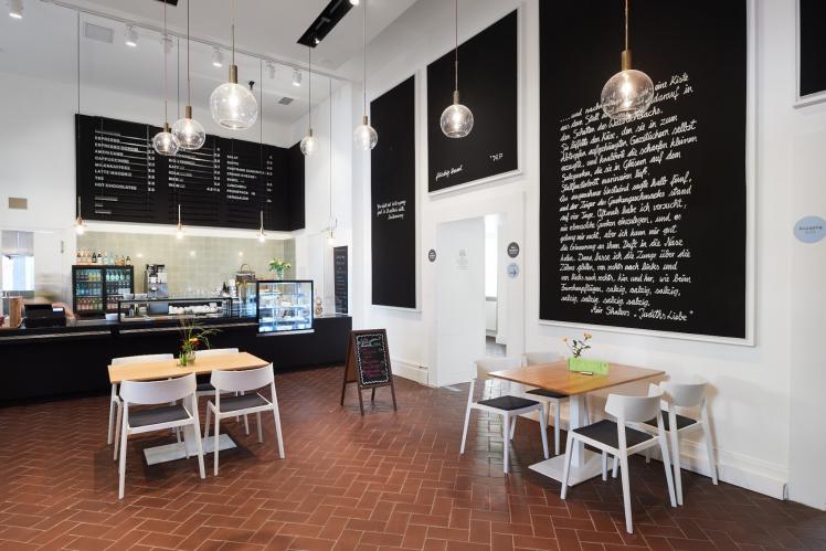 Museum café with counter, tables and food boards 