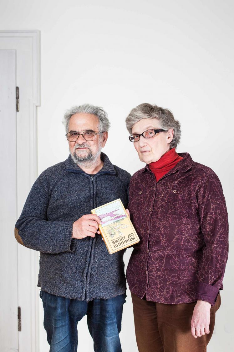 Elderly man and elderly lady holding a book together