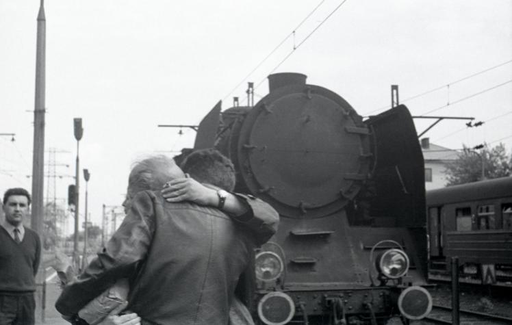 Two men hug at a train station