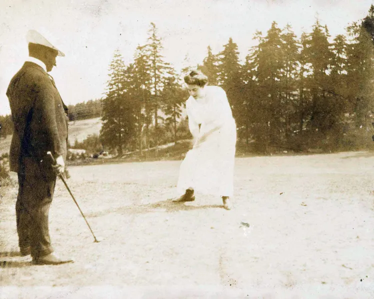 Links im Bild ist ein Mann im Anzug mit Golfschläger zu sehen, in der Mitte eine Frau in weißem Kleid, die sich anschickt, einen Golfball zu schlagen.
