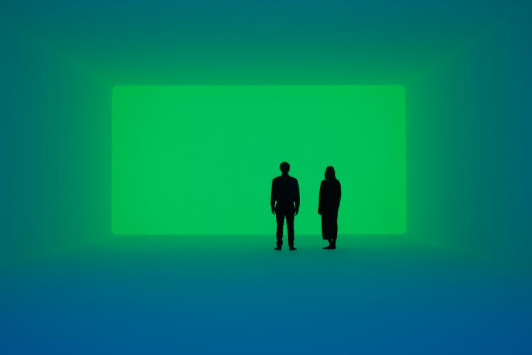 A man and a woman stand in a room flooded with green light