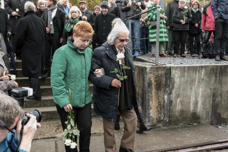 Horst Selbiger mit Petra Pau bei einer Gedenkveranstaltung, in der Hand eine weiße Rose