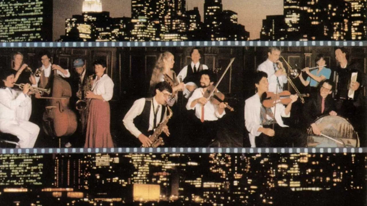 The New York skyline at night can be seen, with a picture of fourteen musicians in the middle.