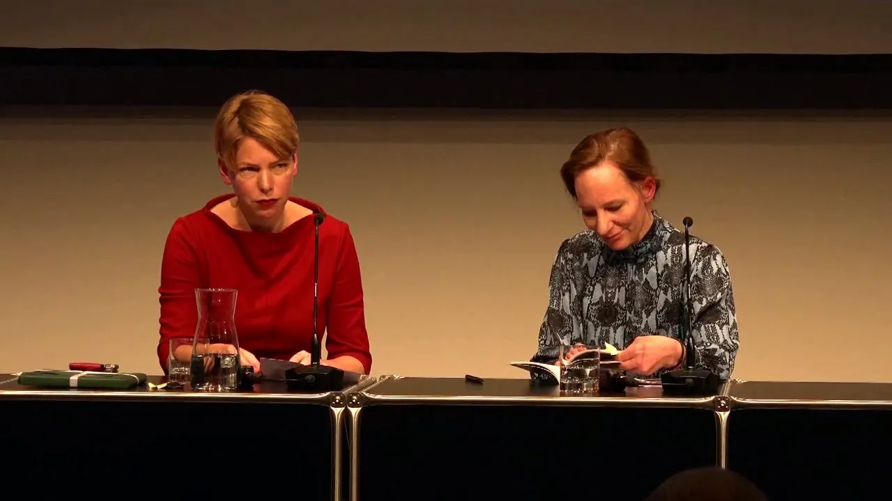 Zwei Frauen unterhalten sich auf einem Podium miteinander.