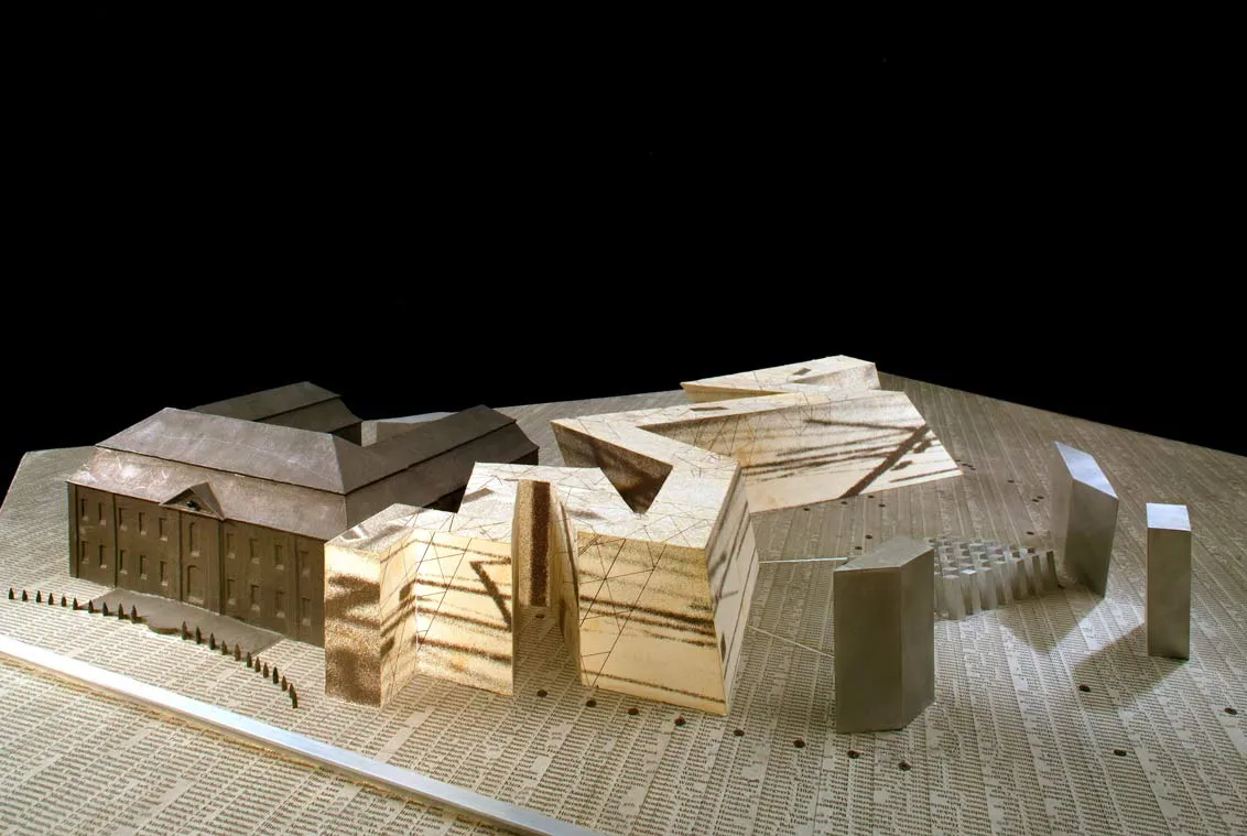 Architectural model of the Jewish Museum Berlin made of wood-based material and cardboard covered with printed and gray-colored paper, with many names written on the base.