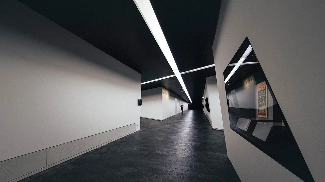 Zwei Achsen-Gänge kreuzen sich im Untergeschoss des Jüdischen Museums. Decke und Boden sind Schwarz.